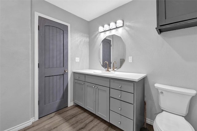 bathroom with hardwood / wood-style flooring, vanity, and toilet