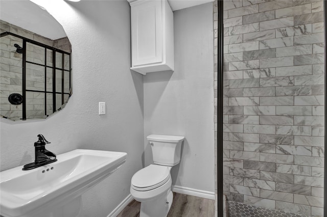 bathroom with toilet, an enclosed shower, sink, and hardwood / wood-style flooring