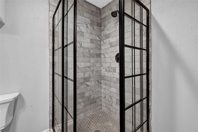 bathroom with toilet and a tile shower