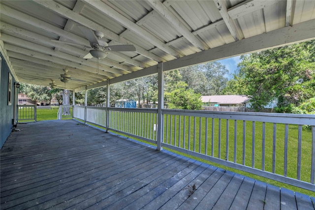 wooden deck with ceiling fan and a yard