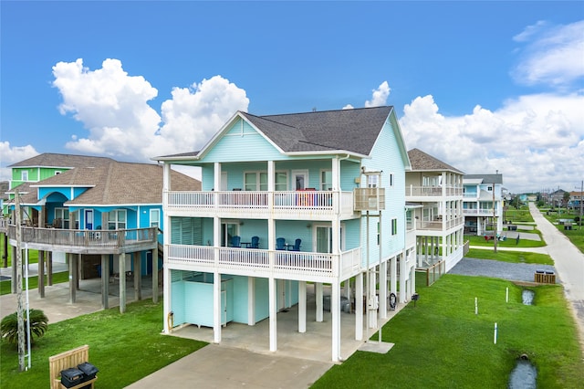 rear view of property featuring a yard, a carport, and a balcony