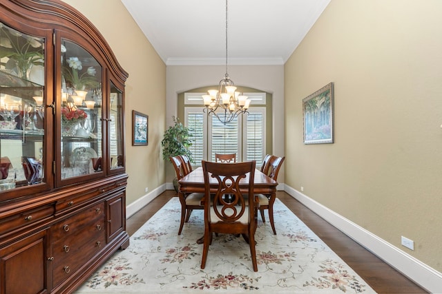 dining room with crown molding, hardwood / wood-style flooring, and an inviting chandelier