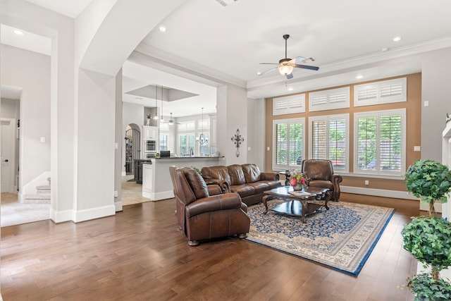 living room with ornamental molding, dark hardwood / wood-style flooring, ceiling fan, and a healthy amount of sunlight