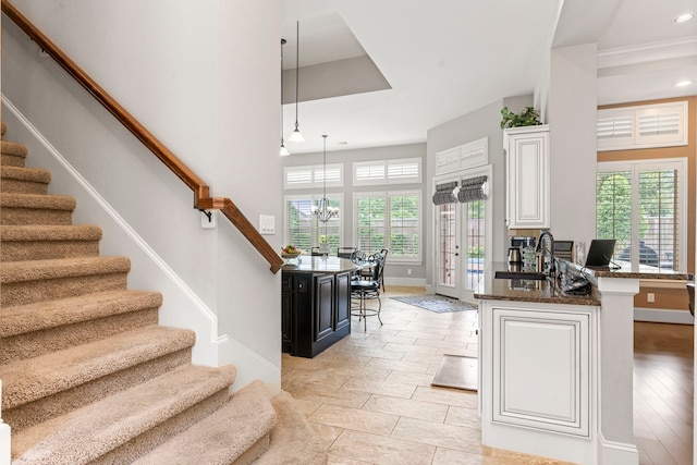 interior space featuring a towering ceiling, sink, and a chandelier