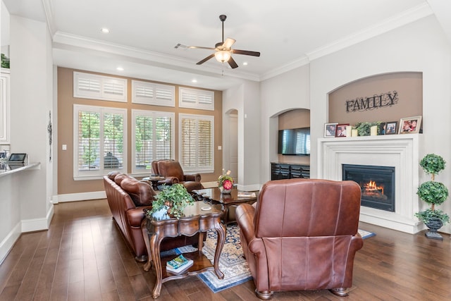 living room with dark wood-type flooring, ceiling fan, and ornamental molding