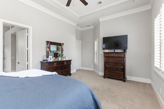 carpeted bedroom with a raised ceiling, ceiling fan, and ornamental molding