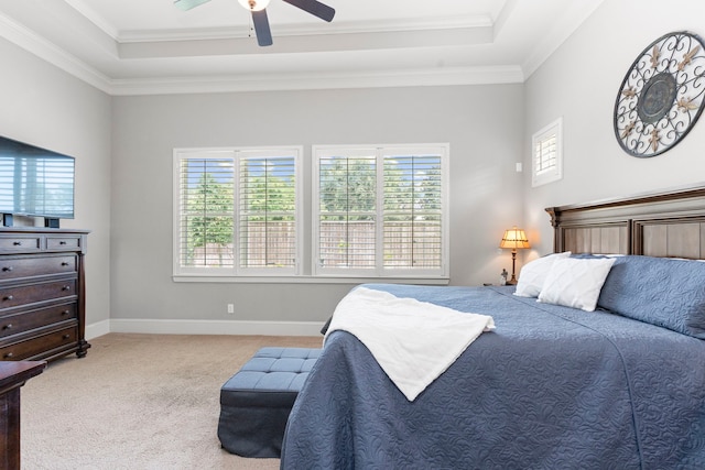 carpeted bedroom with ceiling fan, a raised ceiling, and crown molding