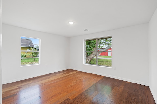 unfurnished room with hardwood / wood-style floors and plenty of natural light