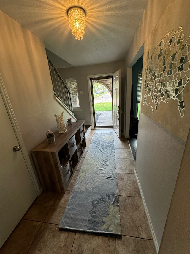 doorway to outside featuring tile patterned floors and an inviting chandelier