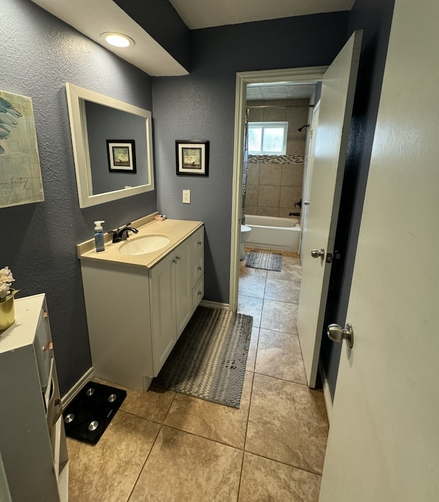 full bathroom with vanity, tiled shower / bath combo, toilet, and tile patterned flooring