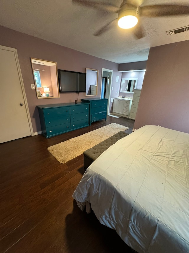 bedroom featuring ceiling fan, dark wood-type flooring, and ensuite bathroom