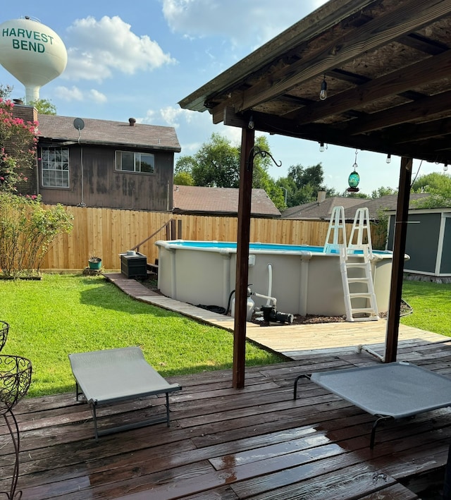 wooden deck featuring a fenced in pool and a lawn