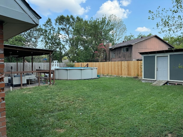 view of yard with a fenced in pool and a storage unit