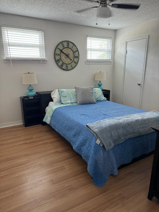 bedroom featuring ceiling fan, a textured ceiling, and hardwood / wood-style flooring