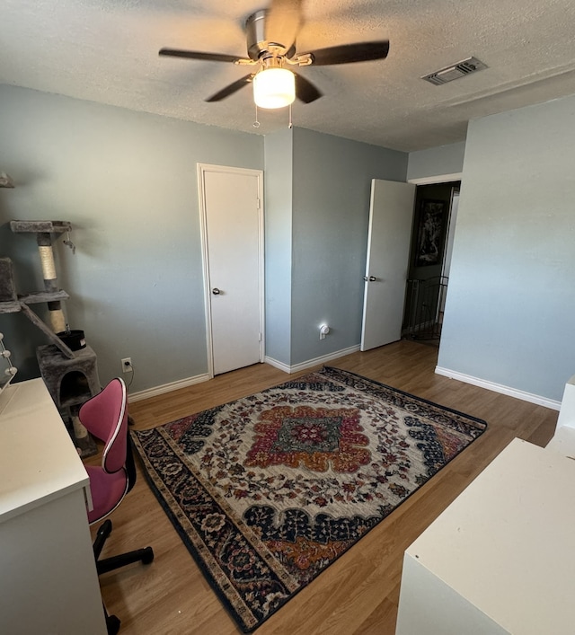 office area featuring ceiling fan, a textured ceiling, and hardwood / wood-style flooring