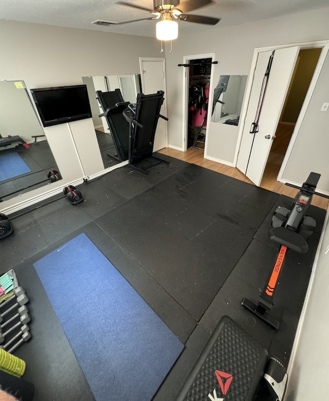 workout room with light hardwood / wood-style flooring and ceiling fan