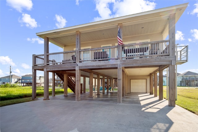 back of property featuring a lawn, a carport, a garage, and a porch