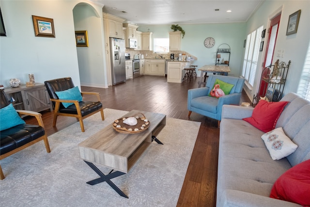 living room featuring crown molding, sink, and hardwood / wood-style flooring