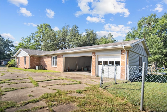 garage with central AC unit and a lawn