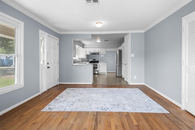 foyer with a wealth of natural light, ornamental molding, and dark hardwood / wood-style floors