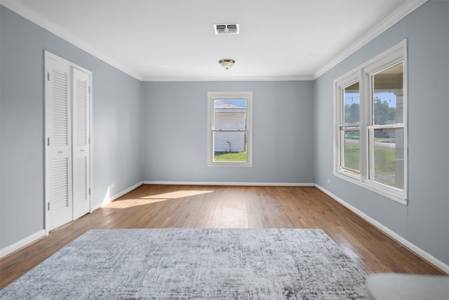 unfurnished room with ornamental molding, hardwood / wood-style floors, and a wealth of natural light