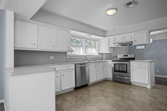 kitchen with appliances with stainless steel finishes, light tile patterned flooring, tasteful backsplash, and white cabinetry