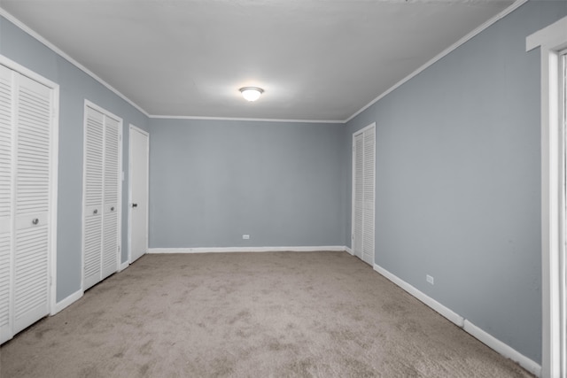 unfurnished bedroom with multiple closets, ornamental molding, and carpet floors