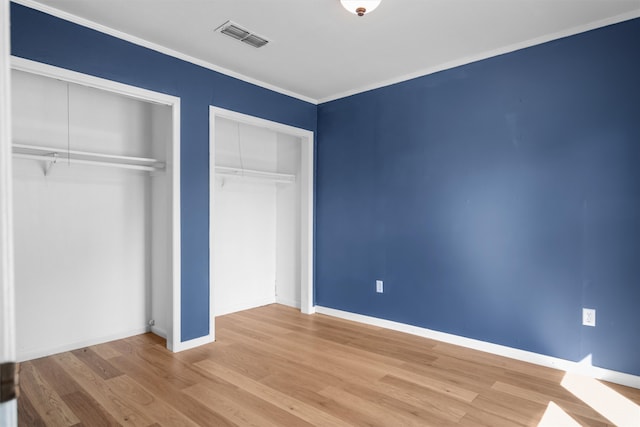 unfurnished bedroom with light wood-type flooring and ornamental molding