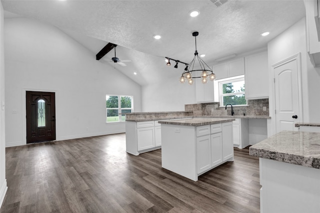 kitchen featuring white cabinetry, dark hardwood / wood-style floors, a center island, and decorative light fixtures