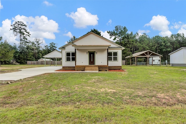 view of front of home featuring an outbuilding, a porch, a carport, and a front yard