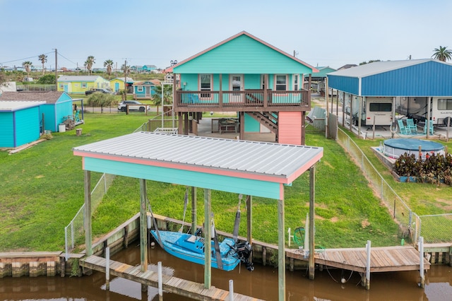 dock area featuring a deck with water view and a yard