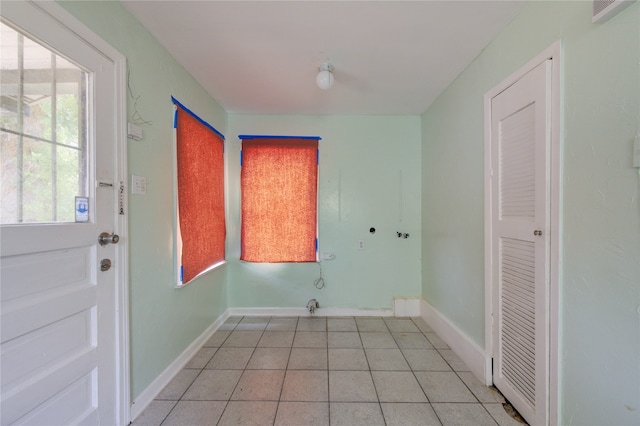 clothes washing area featuring light tile patterned floors