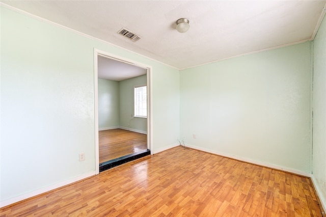 unfurnished room featuring ornamental molding and hardwood / wood-style floors