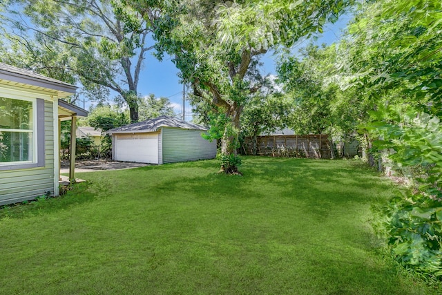 view of yard featuring a garage and an outdoor structure