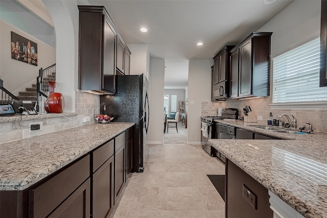 kitchen with gas stove, tasteful backsplash, a healthy amount of sunlight, and sink