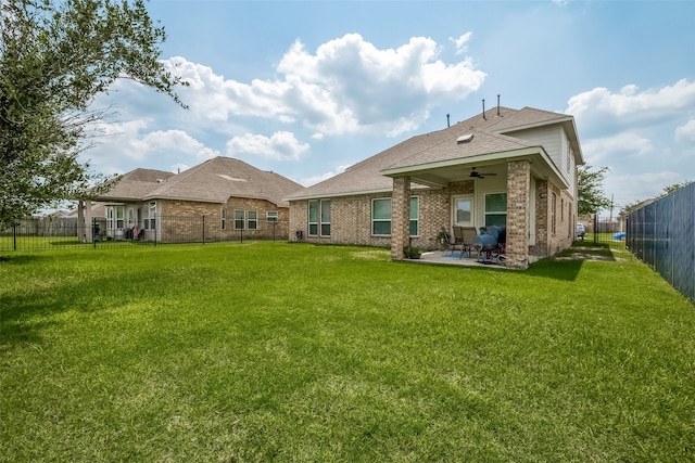 back of property with ceiling fan, a lawn, and a patio area