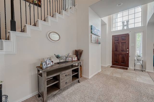 carpeted foyer featuring a high ceiling