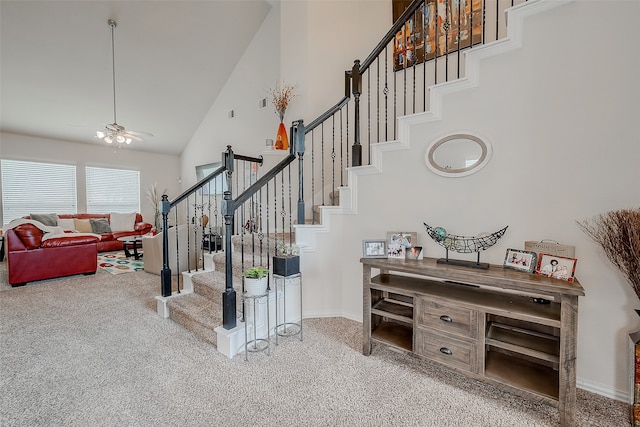 stairs featuring high vaulted ceiling, ceiling fan, and carpet floors