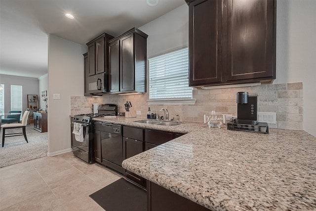 kitchen featuring light stone counters, sink, dark brown cabinets, backsplash, and black appliances