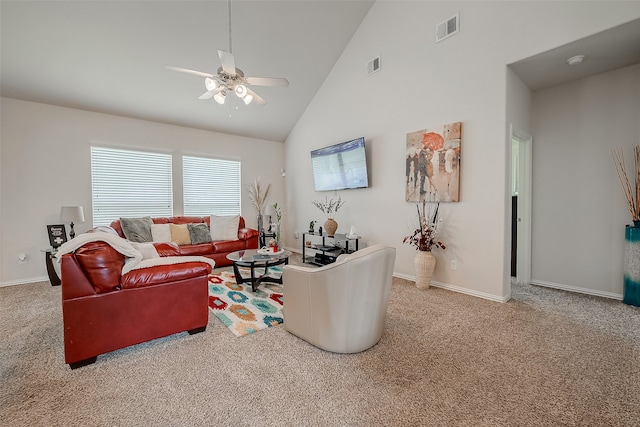 carpeted living room with ceiling fan and high vaulted ceiling