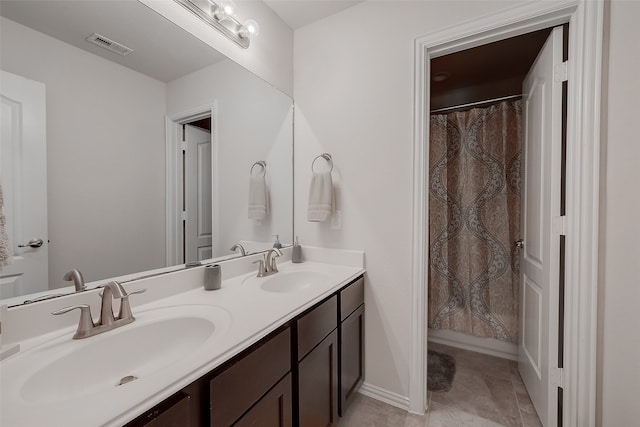 bathroom featuring tile patterned flooring, vanity, and curtained shower