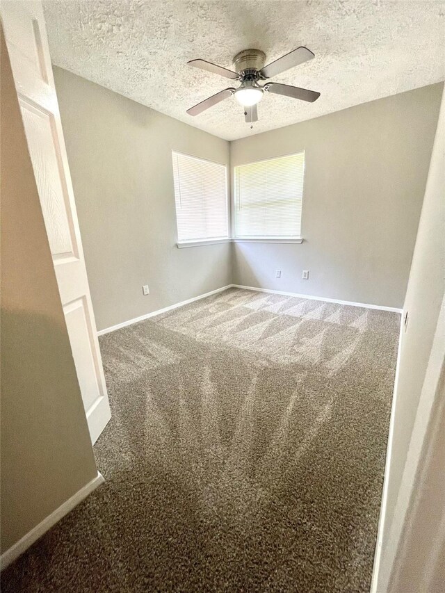 spare room with a textured ceiling, carpet flooring, and ceiling fan