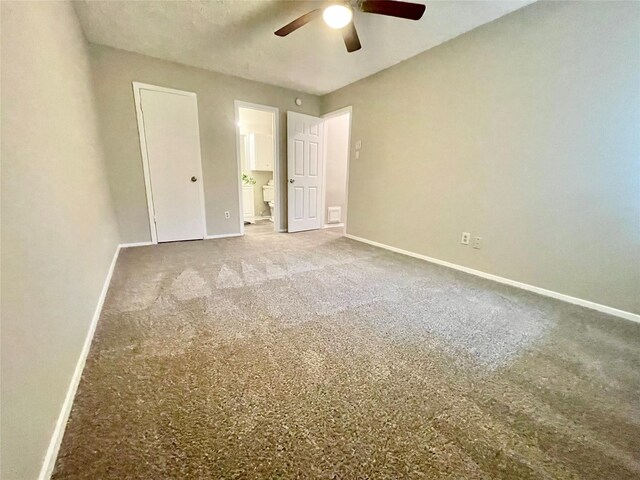 unfurnished bedroom featuring ceiling fan, ensuite bath, and carpet floors