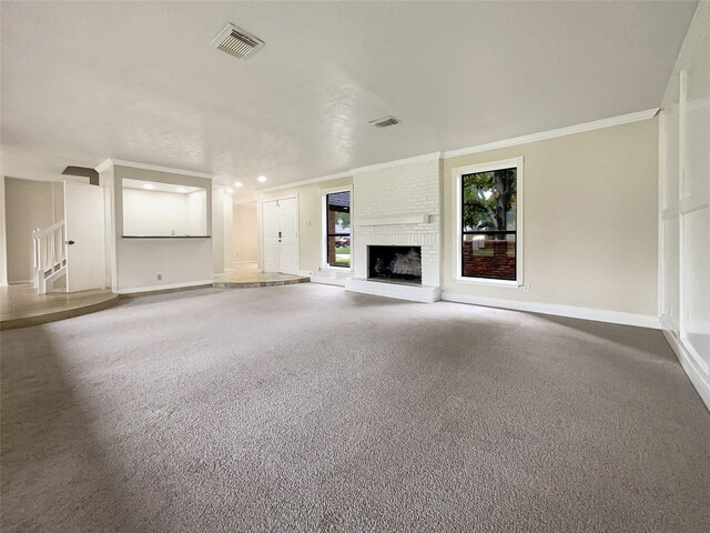 unfurnished living room featuring a fireplace, ornamental molding, and carpet