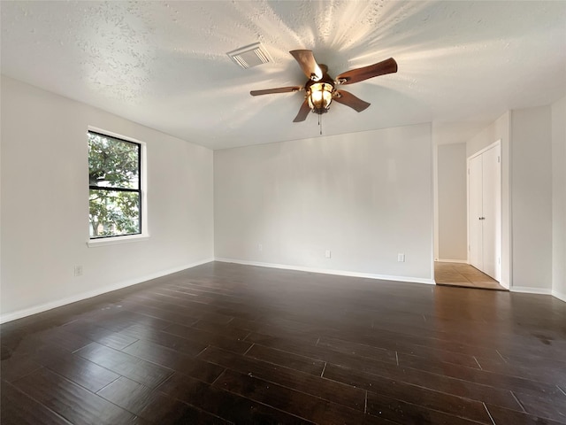 unfurnished room with dark hardwood / wood-style flooring, a textured ceiling, and ceiling fan