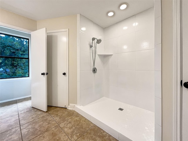 bathroom featuring tile patterned flooring and tiled shower