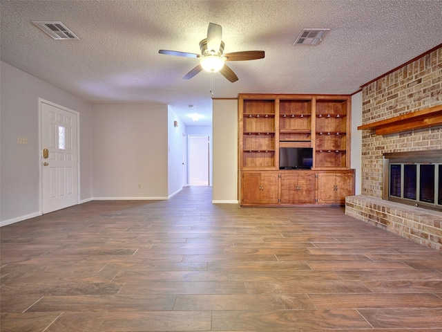 unfurnished living room featuring hardwood / wood-style flooring, ceiling fan, a textured ceiling, and a fireplace