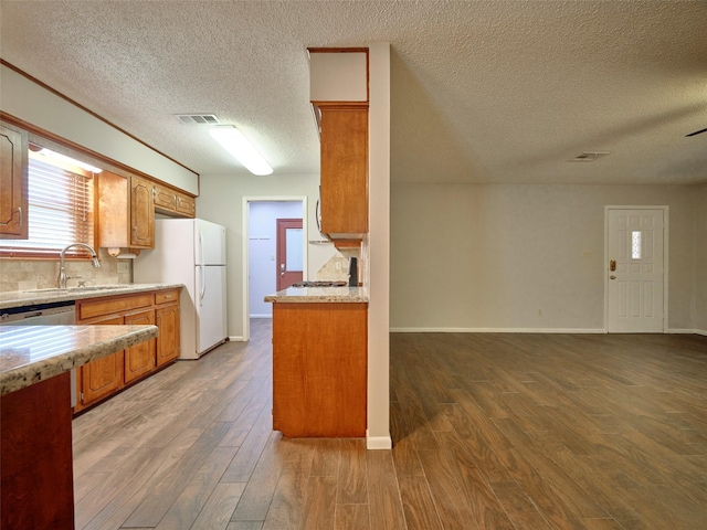 kitchen featuring white refrigerator, wood-type flooring, sink, and stainless steel dishwasher