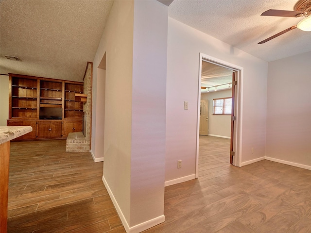 hall with hardwood / wood-style floors and a textured ceiling