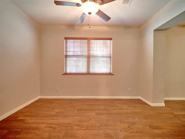 unfurnished room featuring hardwood / wood-style flooring, ceiling fan, and a textured ceiling